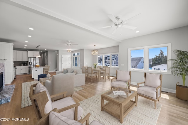 living room with ceiling fan and light hardwood / wood-style flooring