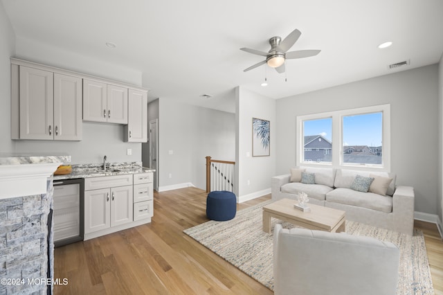 living room with ceiling fan and light wood-type flooring