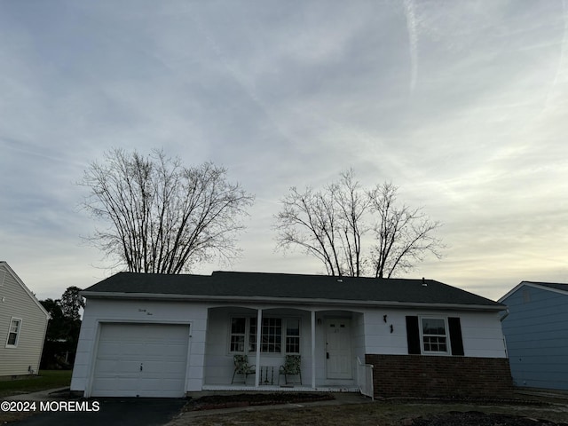 single story home featuring covered porch and a garage