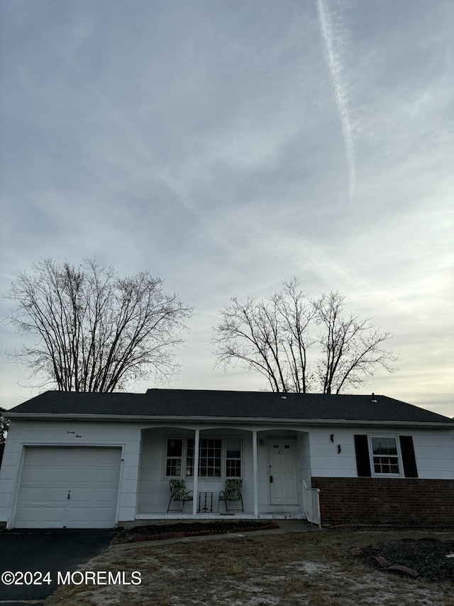 single story home with covered porch and a garage