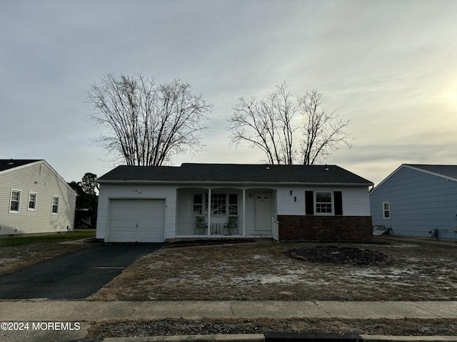 single story home featuring a garage and covered porch