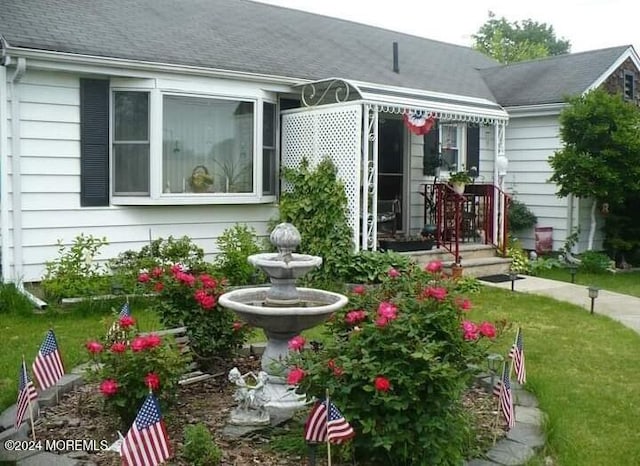 rear view of property featuring a lawn