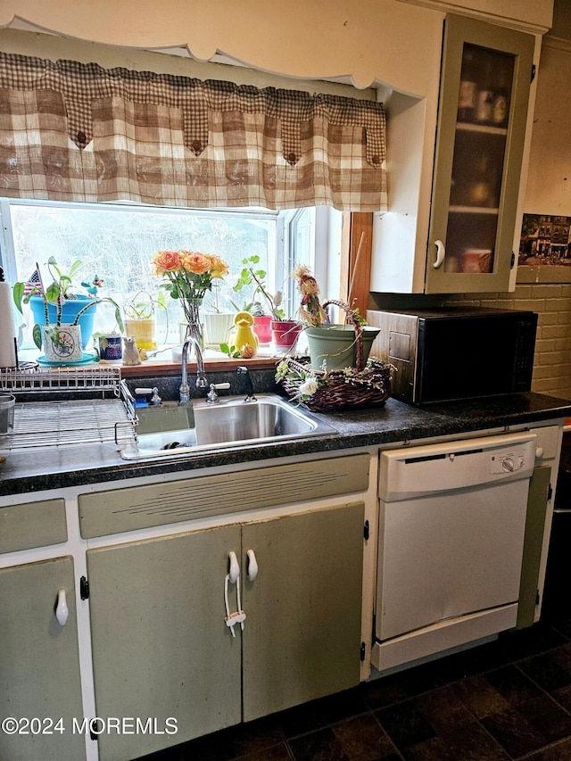 kitchen with decorative backsplash, dishwasher, and sink