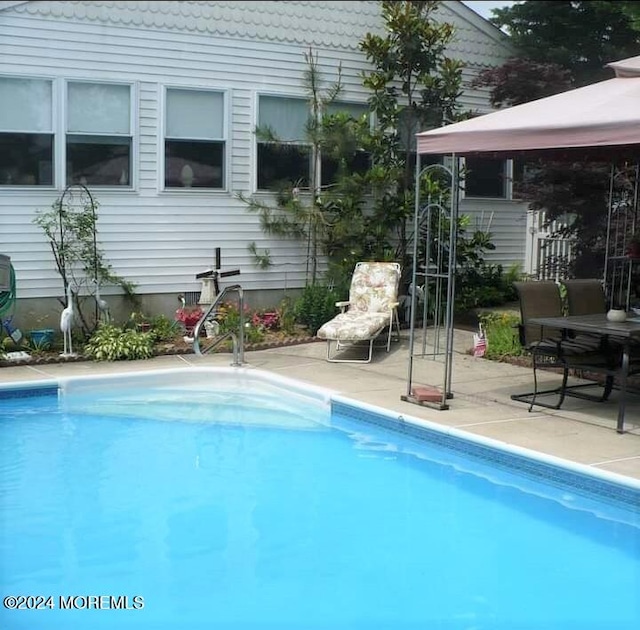 view of swimming pool with a gazebo and a patio