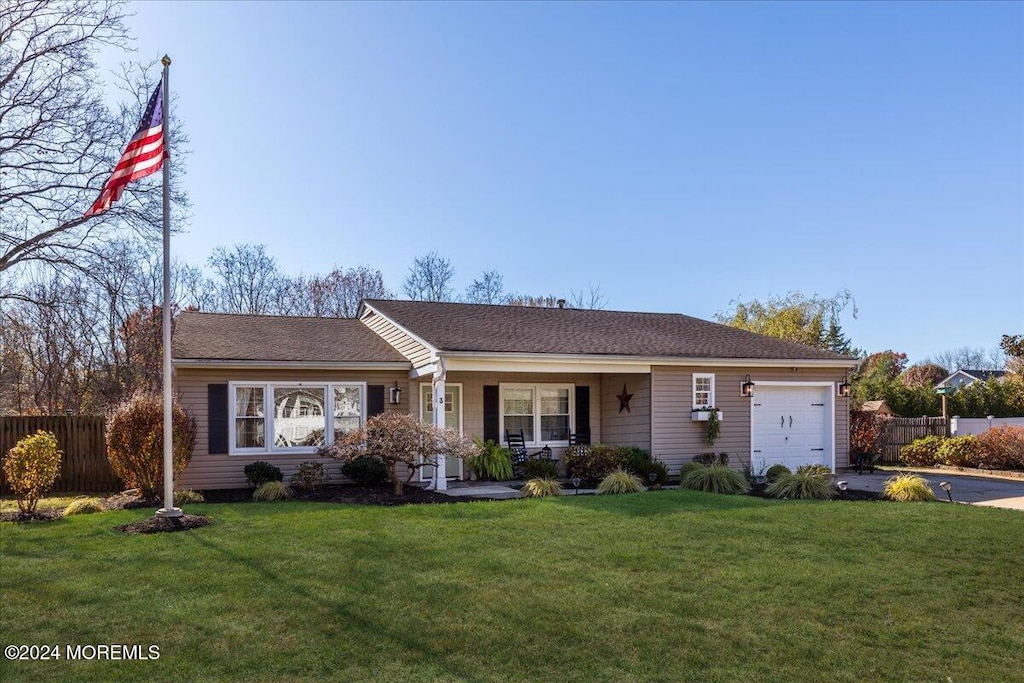 ranch-style house featuring a garage and a front lawn