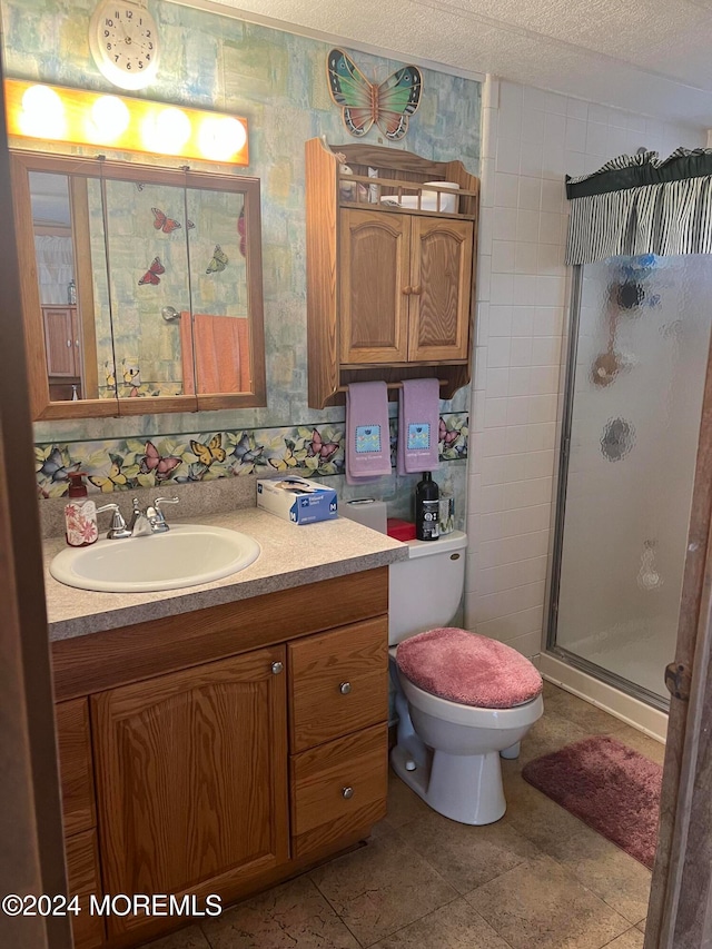 bathroom with vanity, a shower with door, tile patterned floors, toilet, and a textured ceiling