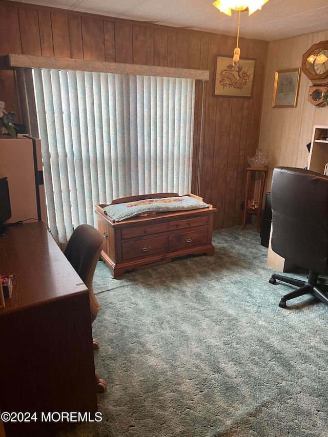 home office featuring carpet flooring, a textured ceiling, and wooden walls