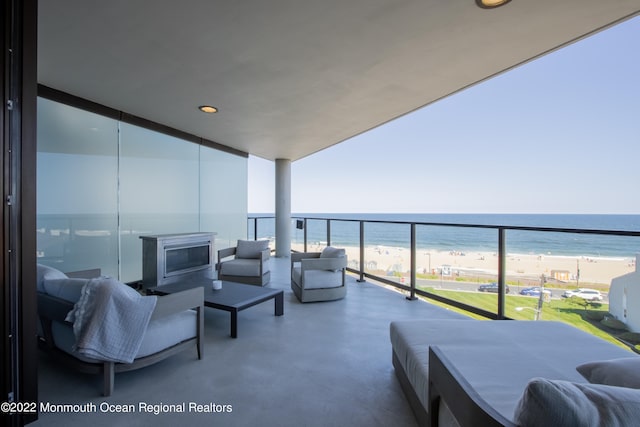 balcony featuring a water view and a beach view