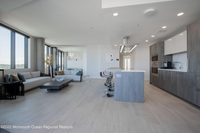 living room with sink and light wood-type flooring