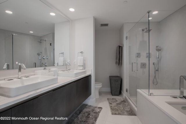 bathroom featuring vanity, a shower with shower door, tile patterned floors, and toilet