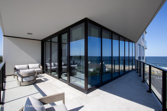 balcony featuring a water view and an outdoor living space