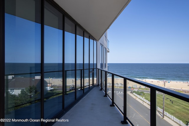 balcony featuring a water view and a view of the beach