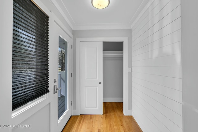 interior space with a closet, ornamental molding, and light hardwood / wood-style flooring