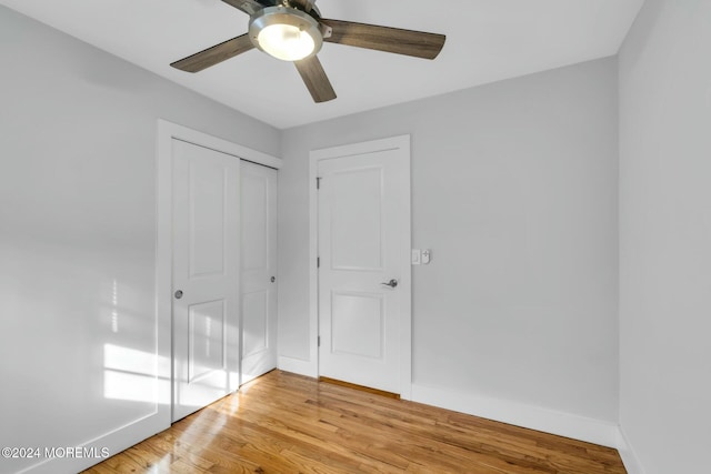 unfurnished bedroom featuring light wood-type flooring, a closet, and ceiling fan