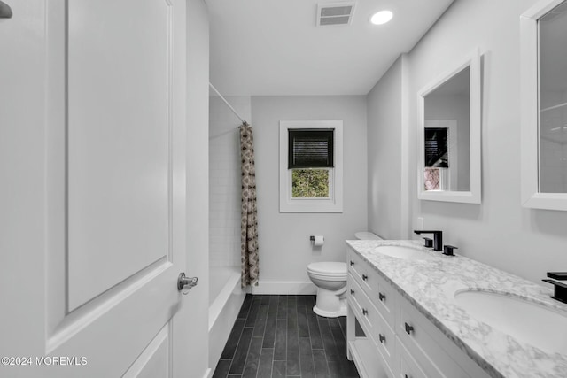 full bathroom featuring shower / bath combo with shower curtain, vanity, and toilet