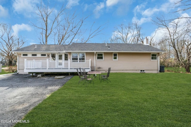 back of property featuring a lawn and a deck