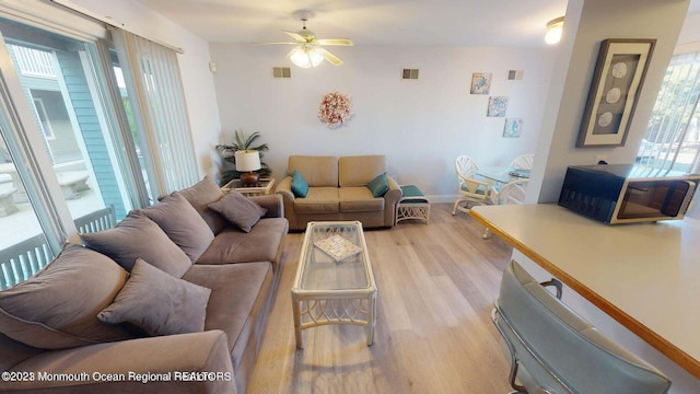 living room with ceiling fan and light wood-type flooring