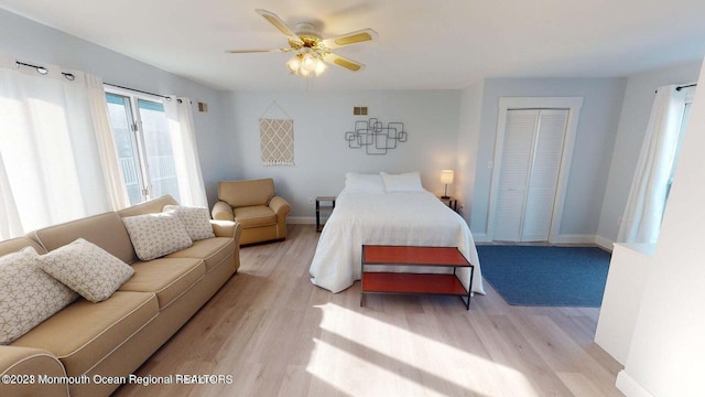 bedroom with ceiling fan, light wood-type flooring, and a closet