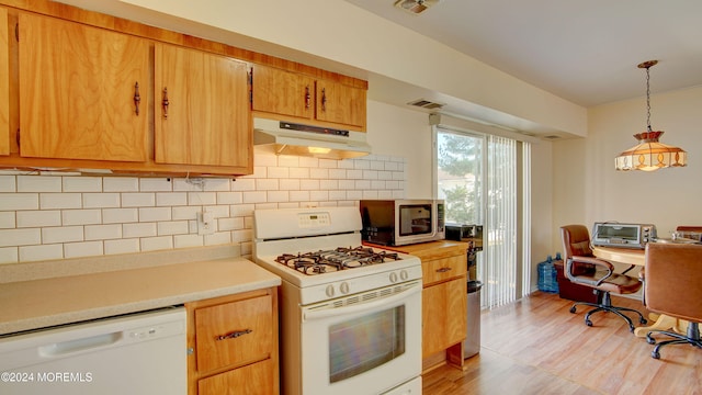 kitchen featuring tasteful backsplash, hanging light fixtures, white appliances, and light hardwood / wood-style floors