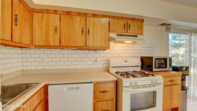 kitchen with decorative backsplash and white appliances