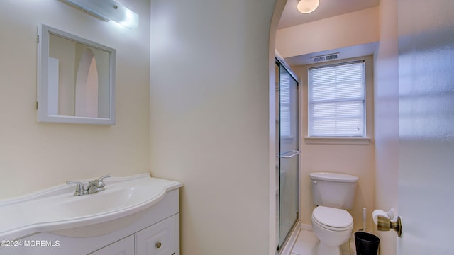 bathroom featuring tile patterned flooring, vanity, toilet, and walk in shower