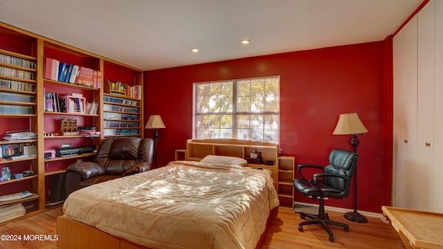 bedroom with light hardwood / wood-style floors and a closet