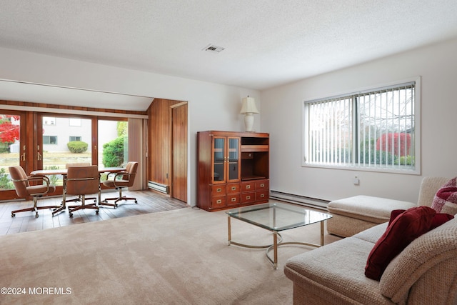 living room with light hardwood / wood-style flooring, a baseboard radiator, and a textured ceiling