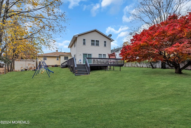 back of house with a lawn and a deck