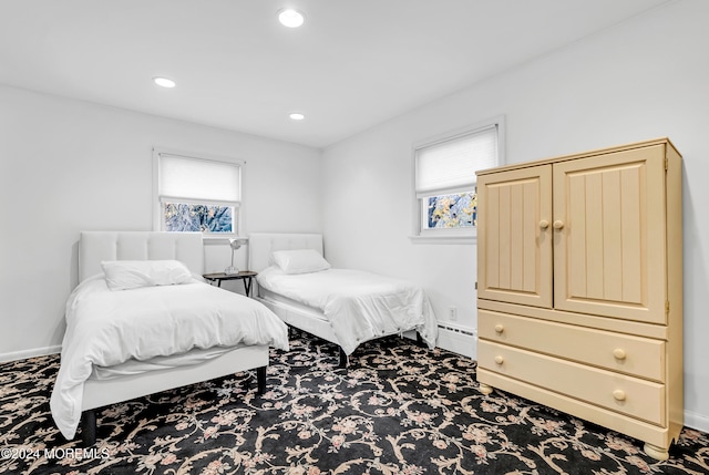 carpeted bedroom with baseboard heating and multiple windows