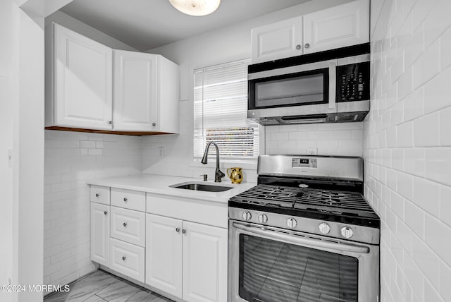 kitchen with sink, white cabinetry, and stainless steel appliances