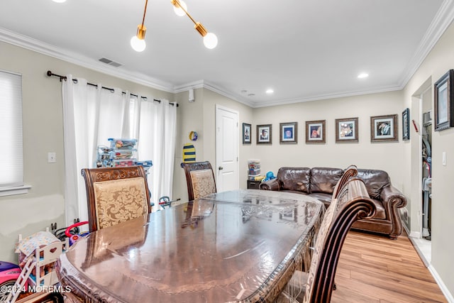 dining area with light hardwood / wood-style floors and ornamental molding