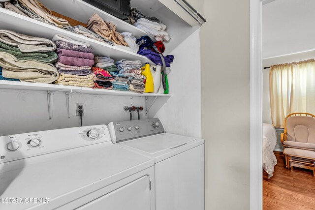 laundry room featuring washer and clothes dryer and light wood-type flooring