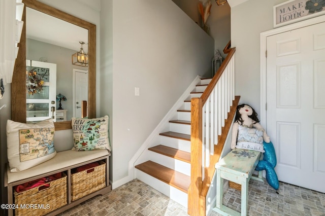 staircase featuring a chandelier