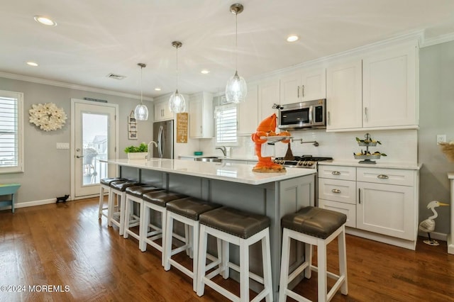 kitchen featuring white cabinetry, plenty of natural light, decorative light fixtures, and appliances with stainless steel finishes