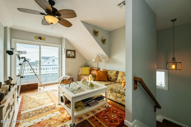 living room with ceiling fan, wood-type flooring, and vaulted ceiling