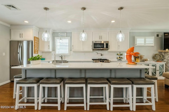 kitchen featuring pendant lighting, white cabinetry, and appliances with stainless steel finishes