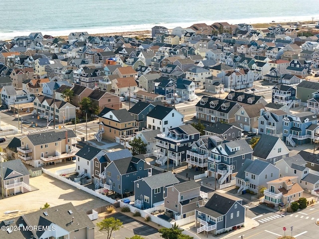 birds eye view of property with a water view and a beach view