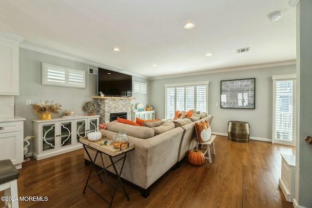 living room featuring dark hardwood / wood-style floors, a stone fireplace, and crown molding