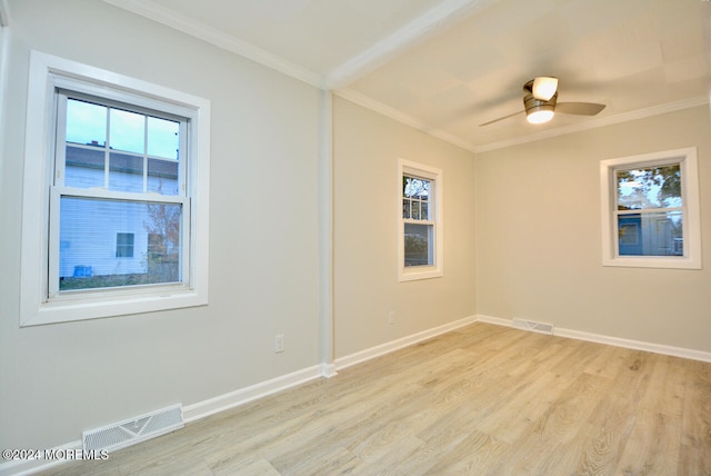 empty room featuring light hardwood / wood-style floors, a wealth of natural light, crown molding, and ceiling fan