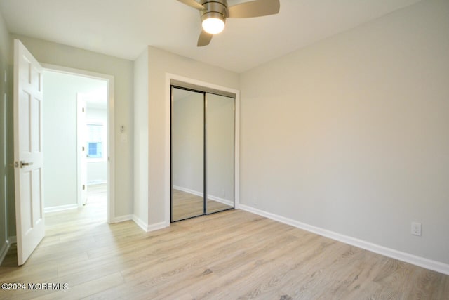 unfurnished bedroom featuring ceiling fan, light wood-type flooring, and a closet