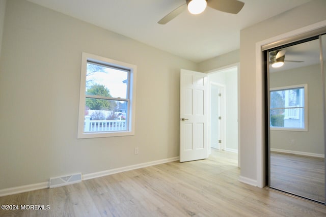 unfurnished bedroom with light wood-type flooring, a closet, and ceiling fan