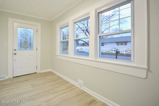 entryway featuring crown molding and light wood-type flooring