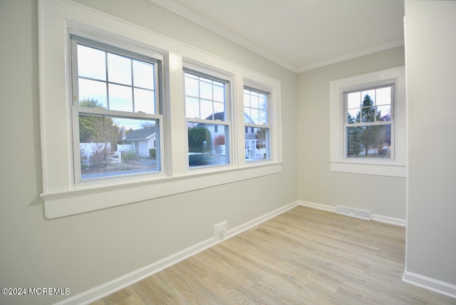 empty room featuring crown molding and light hardwood / wood-style flooring