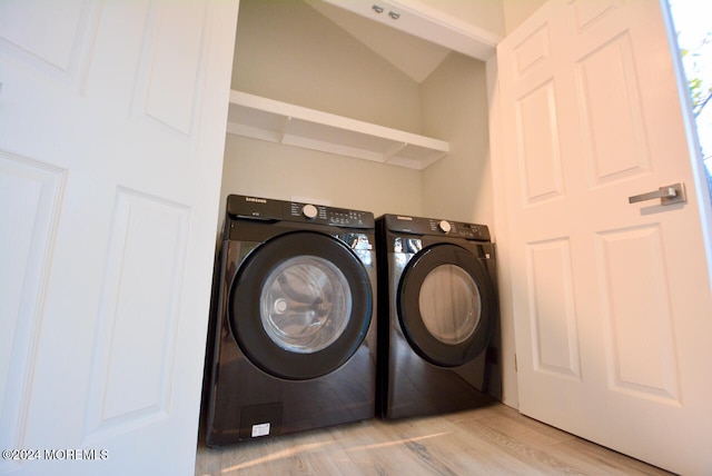 laundry area with washer and clothes dryer and light hardwood / wood-style flooring