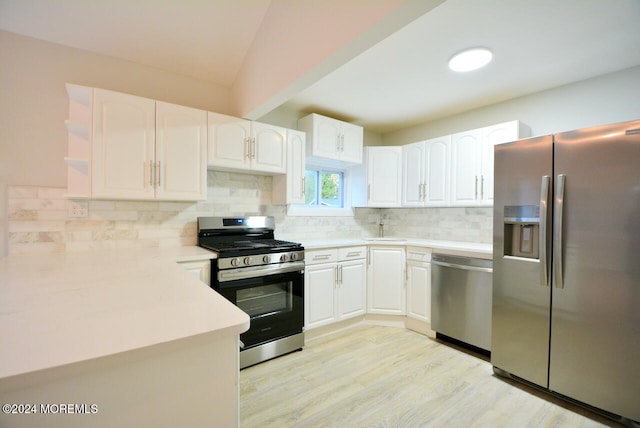 kitchen with backsplash, sink, light hardwood / wood-style floors, white cabinetry, and stainless steel appliances