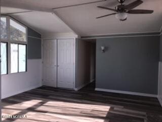 spare room with ceiling fan, dark hardwood / wood-style flooring, and vaulted ceiling