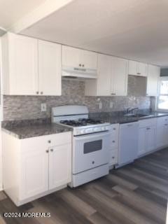 kitchen with decorative backsplash, white appliances, dark wood-type flooring, sink, and white cabinetry