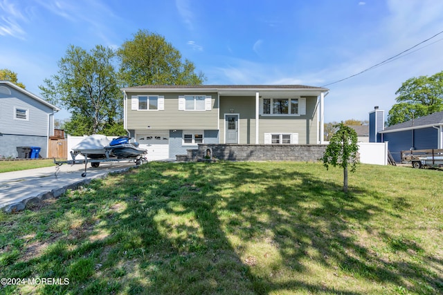 split foyer home with a garage and a front yard