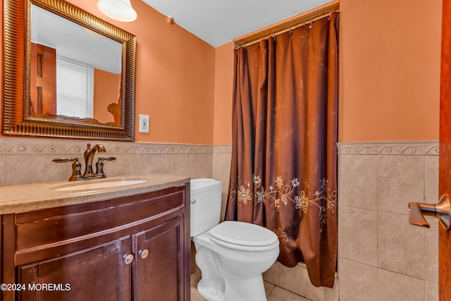 bathroom with vanity, tile walls, and toilet