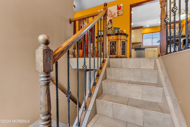 stairway featuring tile patterned floors and sink